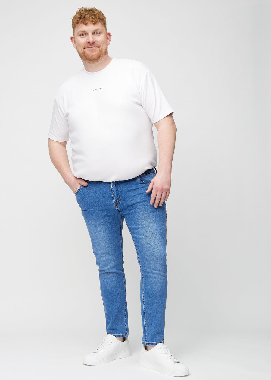 Ganzkörperaufnahme eines Plus-Size-Models in blaue Denim-Jeans im Slim Fit.