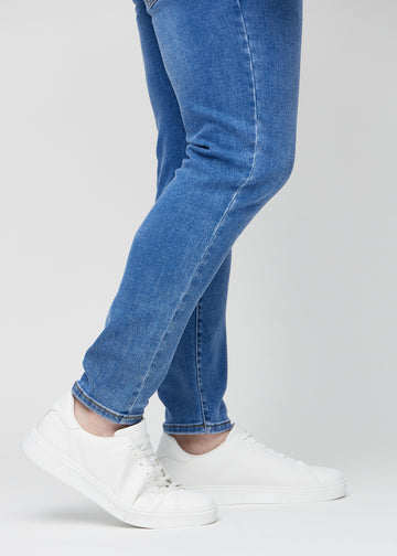 Knöchelbereich eines Plus-Size-Models, der zeigt, wie eng die Jeans anliegen.