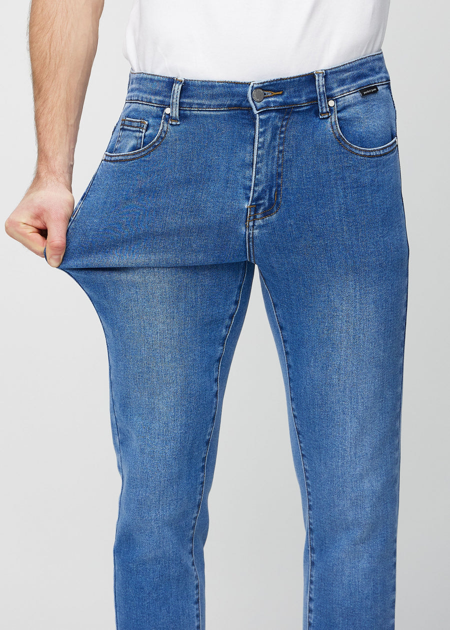 Ein Model dehnt die Jeans am Oberschenkel, um den Stretch des Materials zu zeigen.