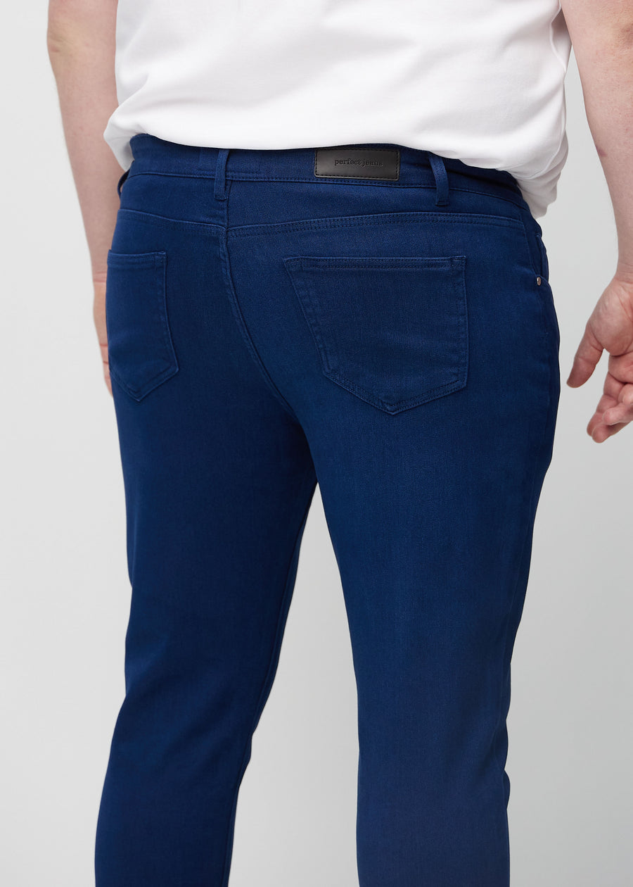 Nahaufnahme von hinten von dunkelblaue Jeans im Slim Fit an einem Plus-Size-Model, die Details zeigt.