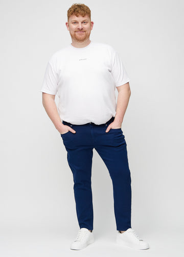 Ganzkörperaufnahme eines Plus-Size-Models in dunkelblaue Jeans im Slim Fit.