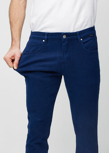 Ein Model dehnt die Jeans am Oberschenkel, um den Stretch des Materials zu zeigen.