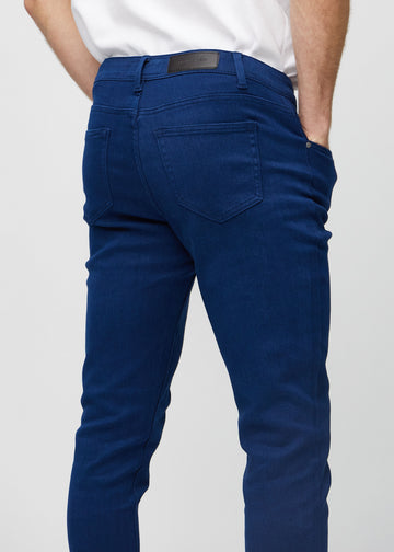 Nahaufnahme von hinten von dunkelblaue Jeans im Slim Fit, die Details zeigt.