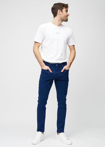 Ganzkörperaufnahme eines Models in dunkelblaue Jeans im Slim Fit.