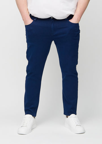 Dunkelblaue Jeans im Slim Fit, Modell Royals, die an einem Plus-Size-Model eng an den Beinen anliegen, von vorne gesehen.