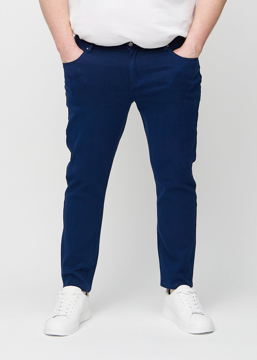 Dunkelblaue Jeans im Slim Fit, Modell Royals, die an einem Plus-Size-Model eng an den Beinen anliegen, von vorne gesehen.
