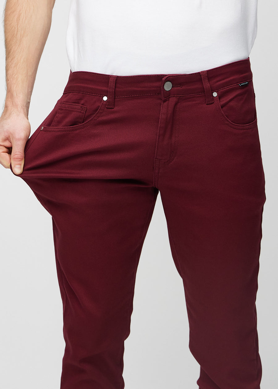 Ein Model dehnt die Jeans am Oberschenkel, um den Stretch des Materials zu zeigen.