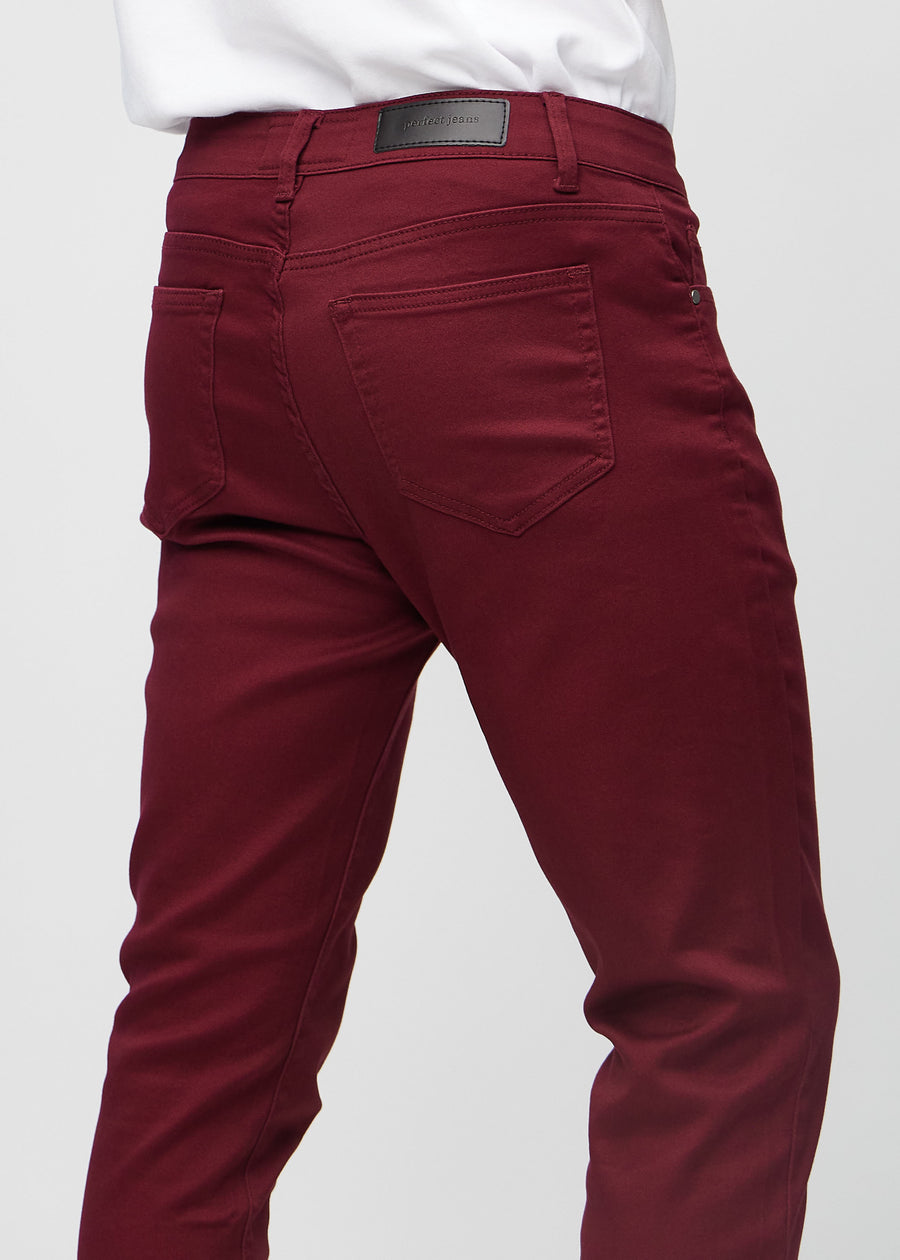 Nahaufnahme von hinten von dunkelrote Jeans im Slim Fit, die Details zeigt.