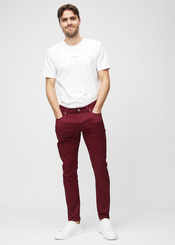 Ganzkörperaufnahme eines Models in dunkelrote Jeans im Slim Fit.