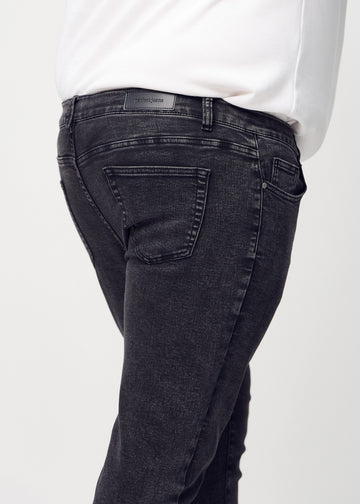 Nahaufnahme von hinten von dunkelgraue Denim-Jeans im Slim Fit an einem Plus-Size-Model, die Details zeigt.