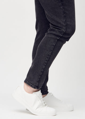 Knöchelbereich eines Plus-Size-Models, der zeigt, wie eng die Jeans anliegen.