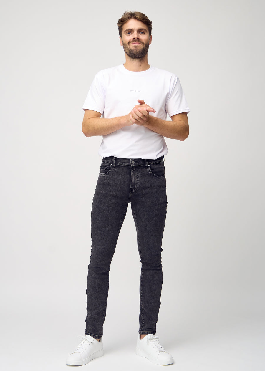 Ganzkörperaufnahme eines Models in dunkelgraue Denim-Jeans im Slim Fit.