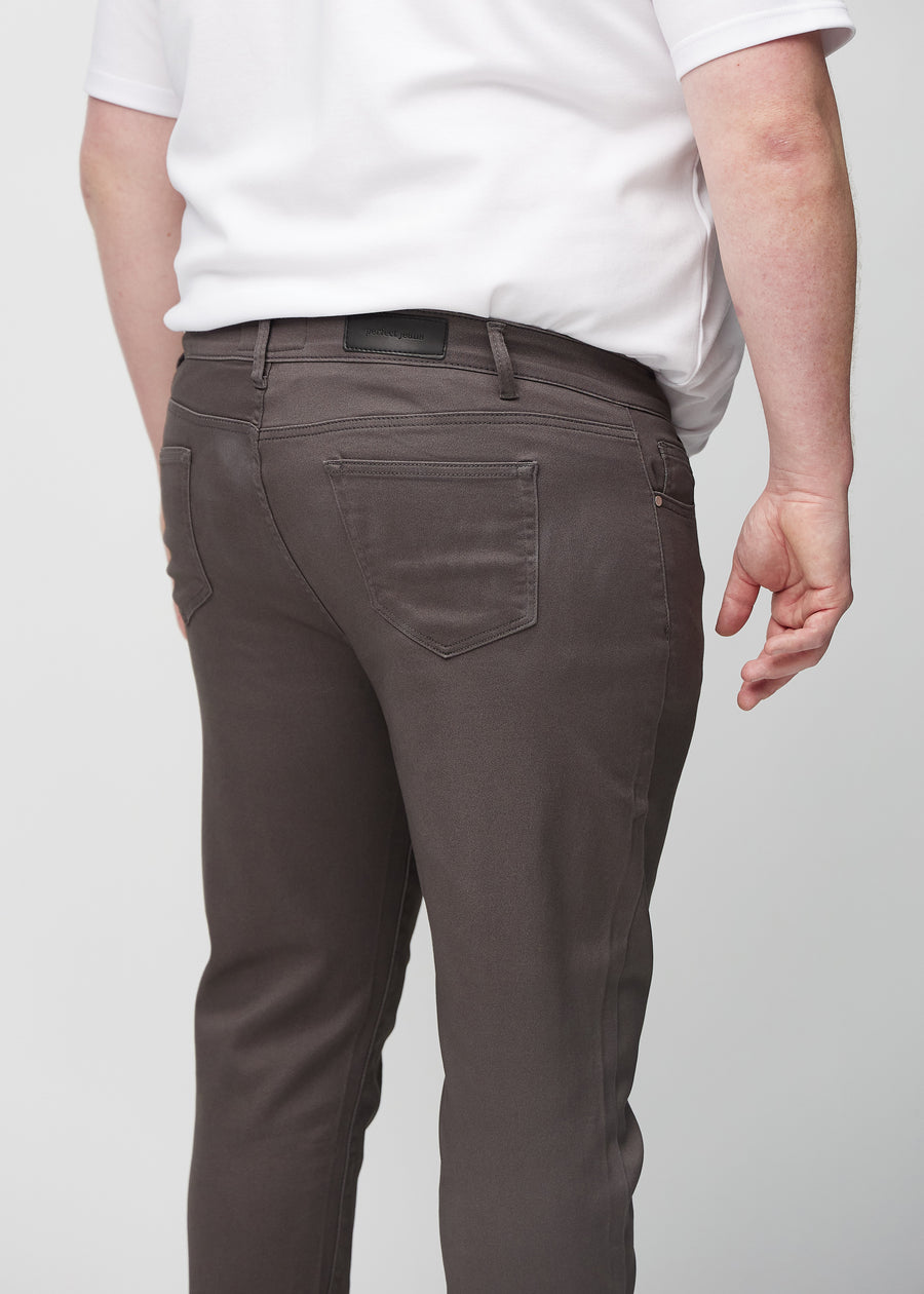 Nahaufnahme von hinten von graubraune Jeans im Slim Fit an einem Plus-Size-Model, die Details zeigt.