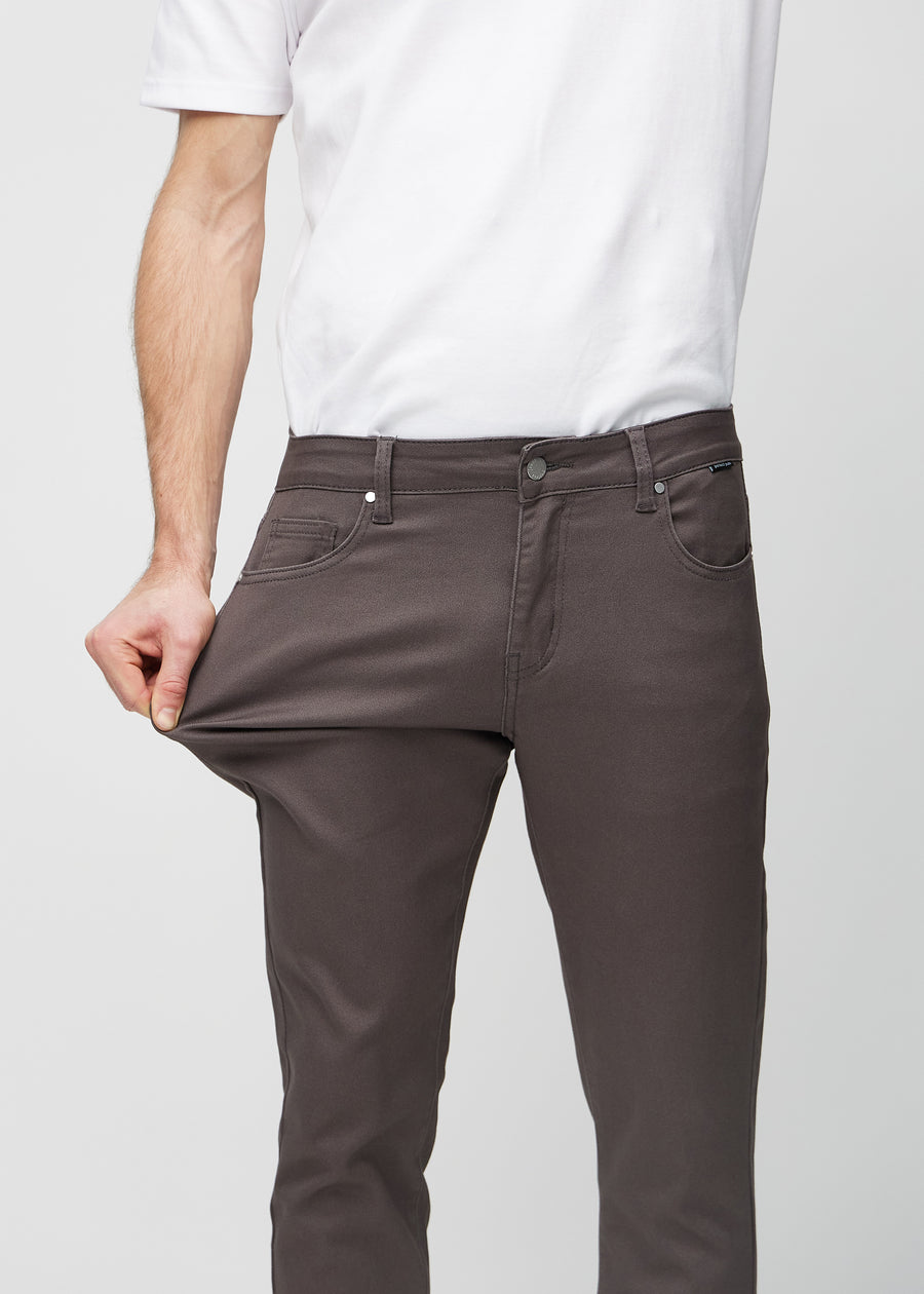 Ein Model dehnt die Jeans am Oberschenkel, um den Stretch des Materials zu zeigen.