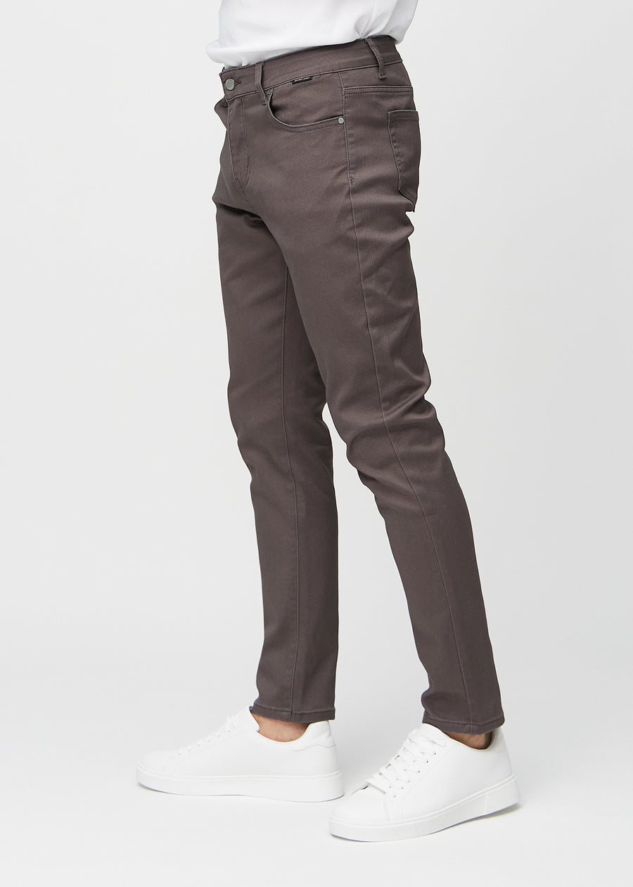 Graubraune Jeans im Slim Fit, von der Seite an einem Model gesehen.