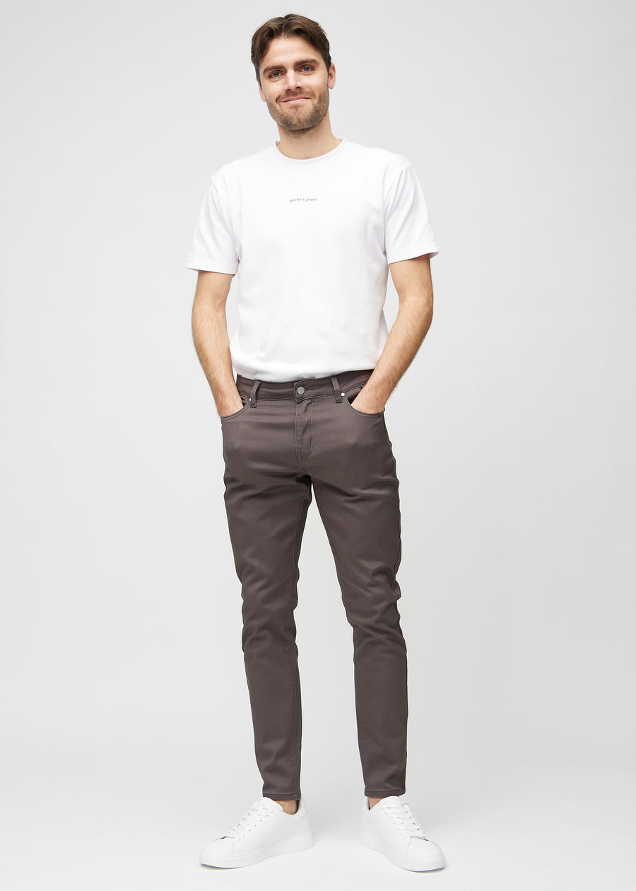 Ganzkörperaufnahme eines Models in graubraune Jeans im Slim Fit.