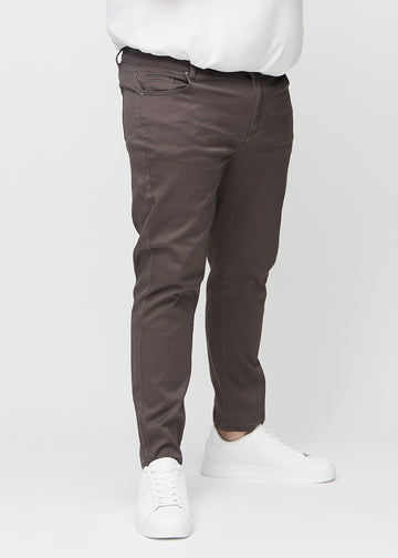 Graubraune Jeans im Slim Fit, Modell Thunders, die an einem Plus-Size-Model eng an den Beinen anliegen, von vorne gesehen.