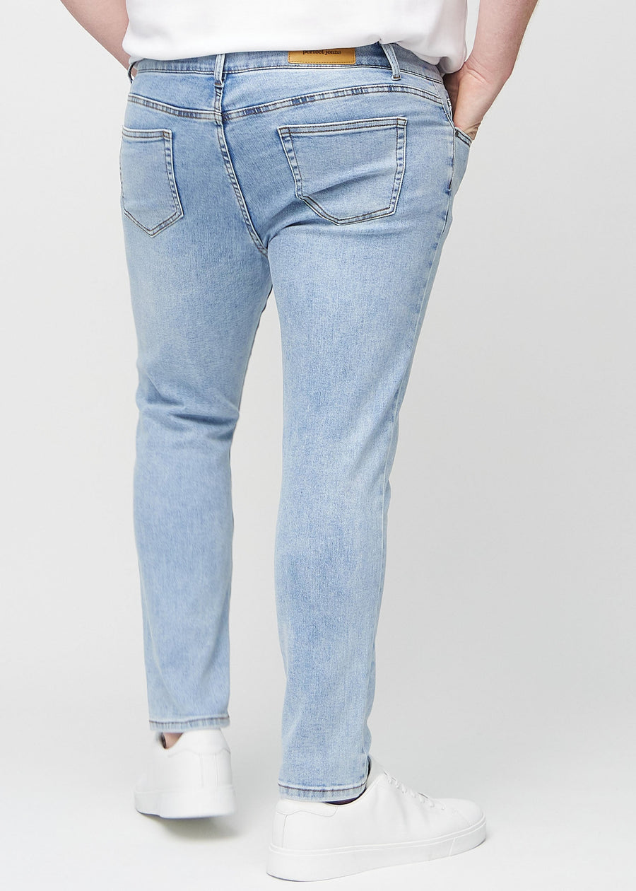 Hellblaue Denim-Jeans im Slim Fit, von hinten an einem Plus-Size-Model gesehen, um die gesamte Jeans zu zeigen.