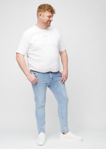 Ganzkörperaufnahme eines Plus-Size-Models in hellblaue Denim-Jeans im Slim Fit.