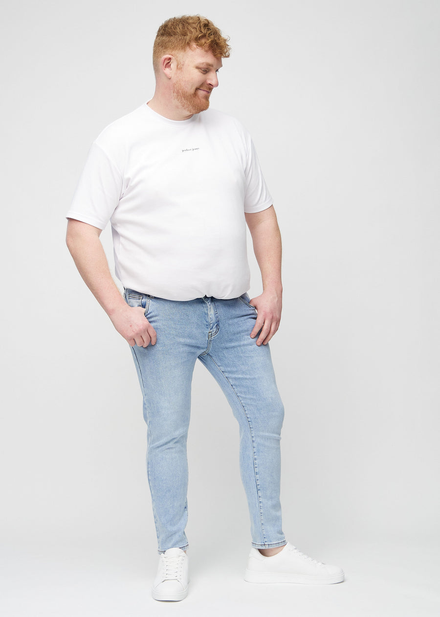 Ganzkörperaufnahme eines Plus-Size-Models in hellblaue Denim-Jeans im Slim Fit.