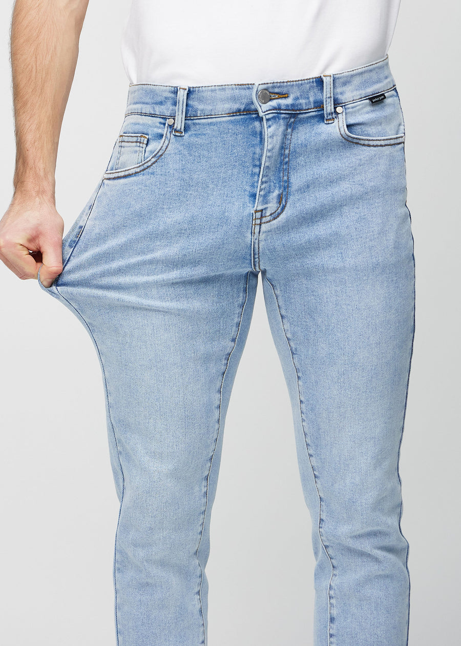 Ein Model dehnt die Jeans am Oberschenkel, um den Stretch des Materials zu zeigen.