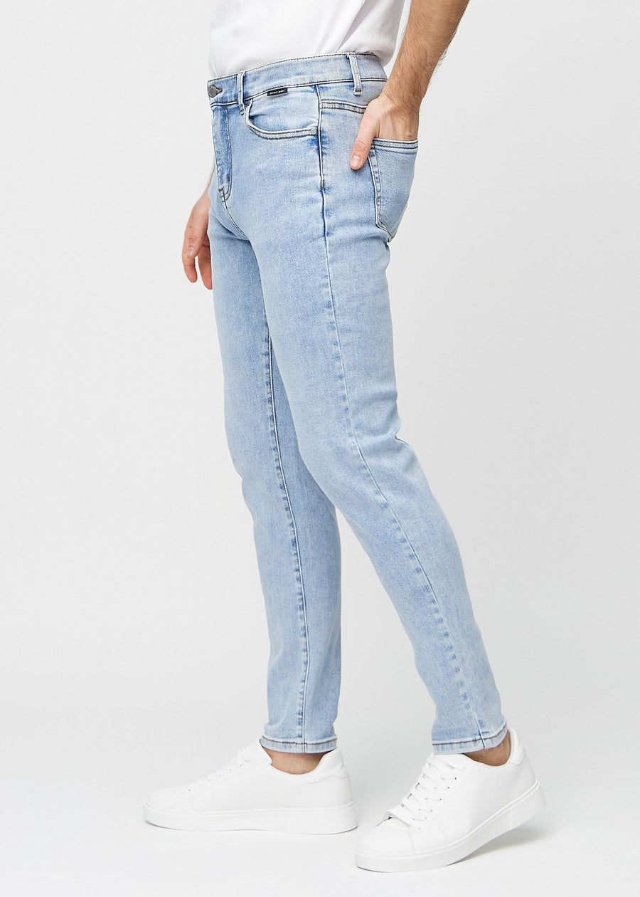 Hellblaue Denim-Jeans im Slim Fit, von der Seite an einem Model gesehen.