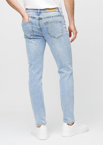 Hellblaue Denim-Jeans im Slim Fit, von hinten gesehen, um die gesamte Jeans zu zeigen.