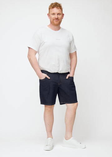 ganzkörperbild eines plus-size-models in dunkelblauen denim shorts für herren in der farbe midnights mit regular-passform.