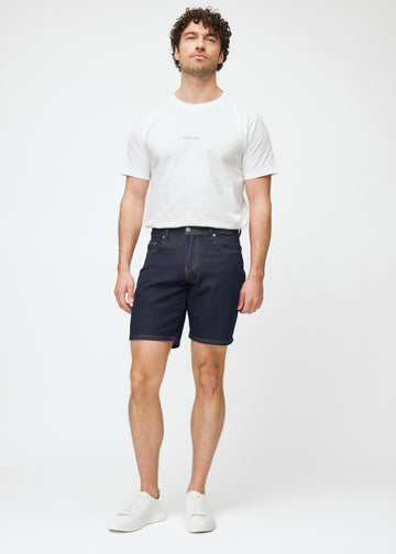 ganzkörperbild eines models in dunkelblauen denim shorts für herren in der farbe midnights mit regular-passform.