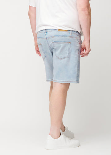Hellblaue Denim-Shorts für Herren in der Farbe Waves von hinten an einem Plus-Size-Model gesehen, sodass die Länge bis knapp über das Knie zu sehen ist.