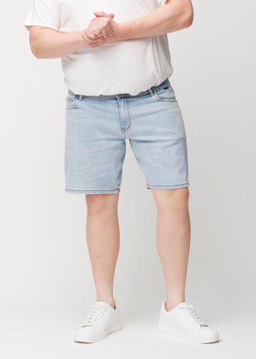 Hellblaue Denim-Shorts für Herren in der Farbe Waves mit regular Passform, von vorne an einem Plus-Size-Model gesehen, die natürlich an der Hüfte sitzt und an den Oberschenkeln Luft gibt.