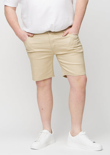 Beige middle-slim Shorts, die gerade am Oberschenkel sitzen und knapp über dem Knie enden, an einem Plus-Size-Model von vorne gesehen.