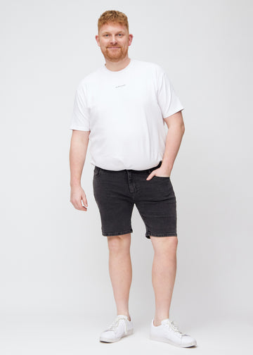 Ganzkörperbild eines Plus-Size-Models in dunkelgrauen Denim middle-slim Shorts.
