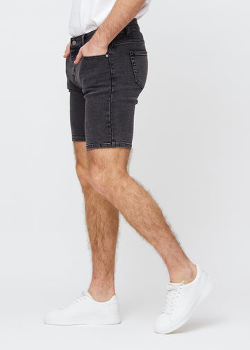 Dunkelgraue Denim middle-slim Shorts von der Seite am Model gesehen.
