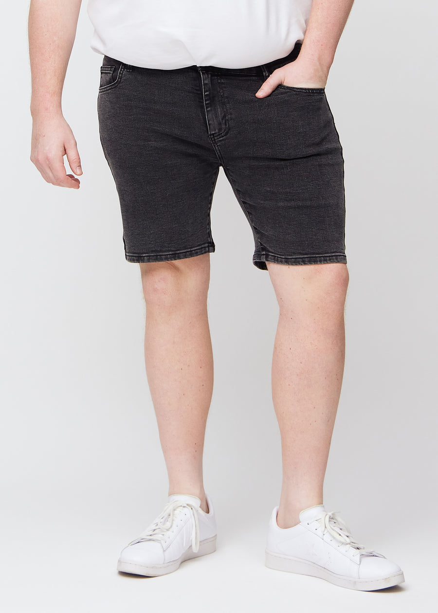 Dunkelgraue Denim middle-slim Shorts, die gerade am Oberschenkel sitzen und knapp über dem Knie enden, an einem Plus-Size-Model, von vorne gesehen.