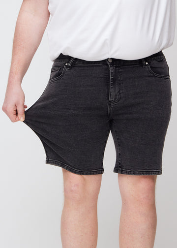 Das Plus-Size-Model zieht die Shorts am Oberschenkel auseinander, um den Stretch zu zeigen.
