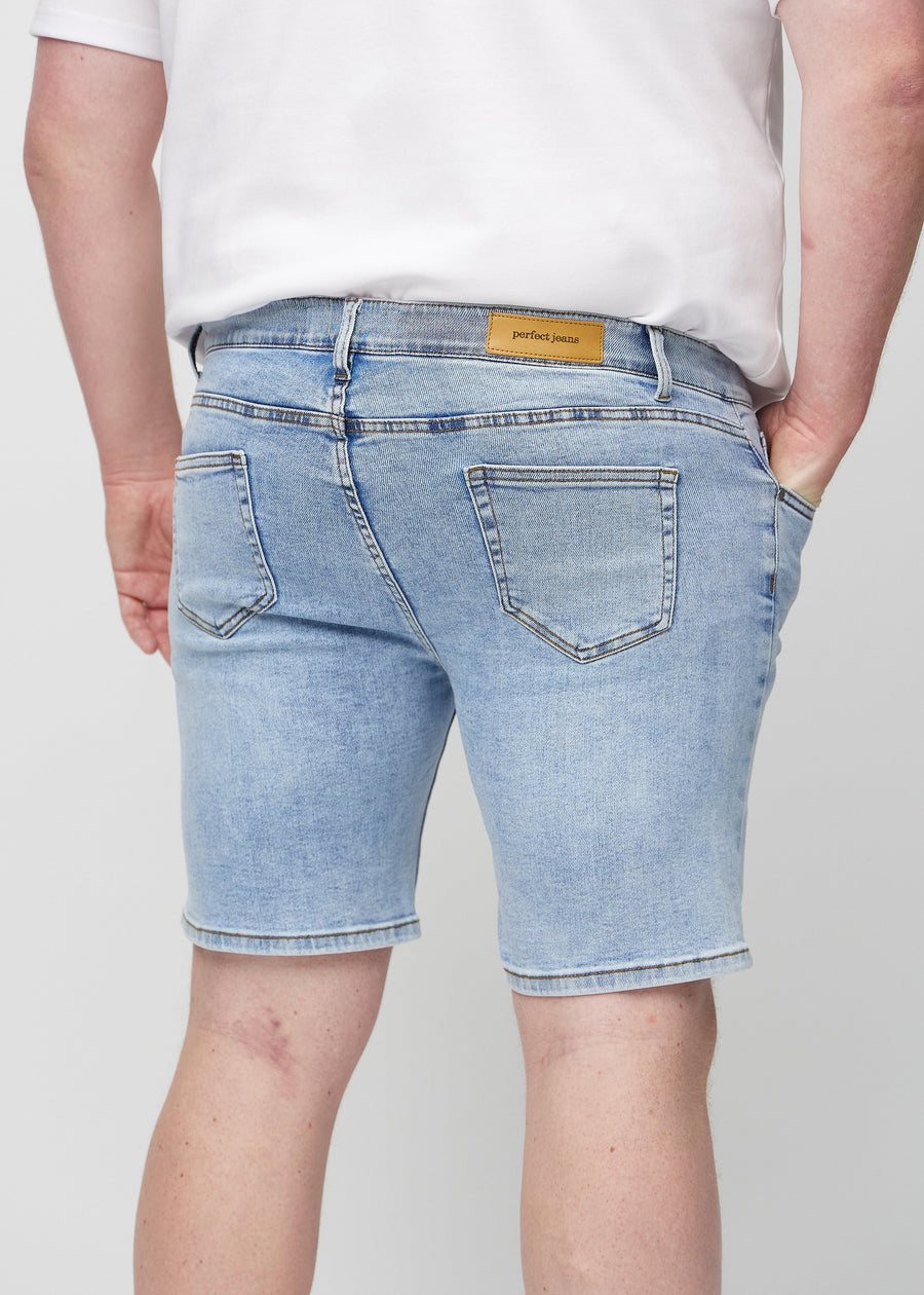 Hellblaue Denim middle-slim Shorts von hinten aus der Nähe an einem Plus-Size-Model gesehen, um Details zu zeigen.