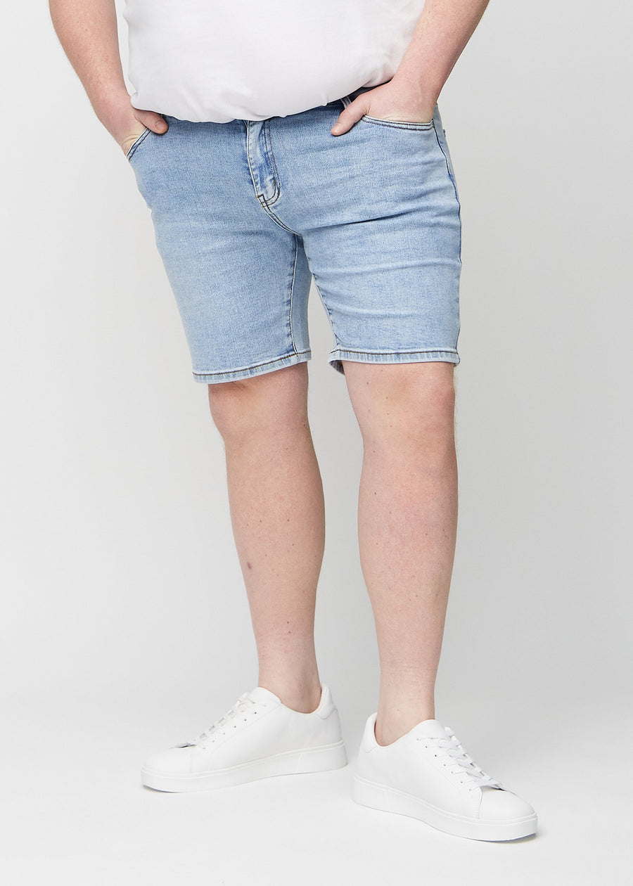 Hellblaue Denim middle-slim Shorts, die gerade am Oberschenkel sitzen und knapp über dem Knie enden, an einem Plus-Size-Model von vorne gesehen.