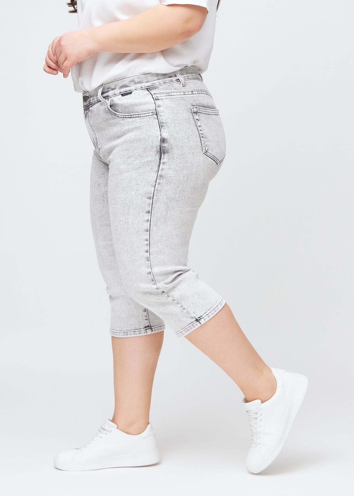 Lysegrå denim slim capris i farven Ashes – set fra siden på en plus-size model, så man ser pasform og silhuet.