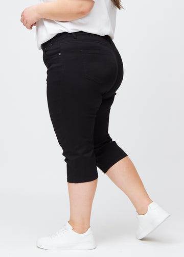  Sorte slim capris i farven Ravens – set fra siden på en plus-size model.
