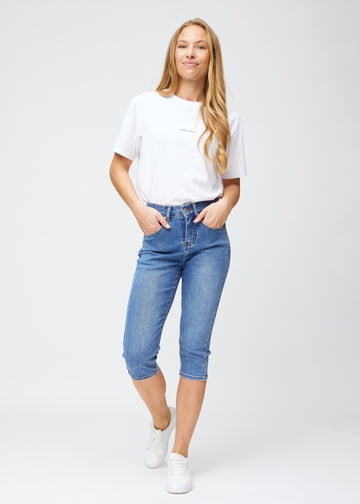 Fuldt billede af model iført blå denim slim capris.