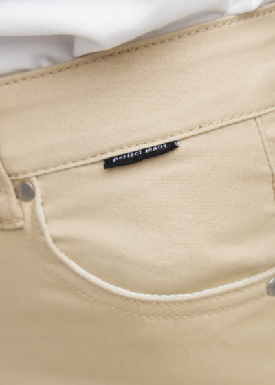 Forlommen på et par beige slim jeans, hvor man kan se logoet.