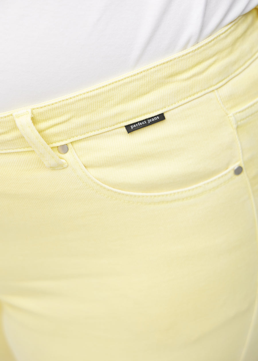 Forlommen på et par lysegule regular middle shorts, hvor man kan se logoet på en plus-size model.