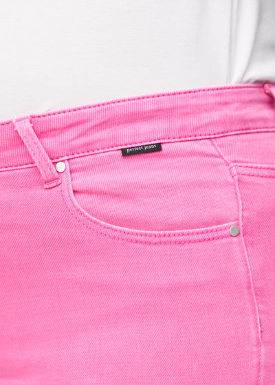 Detaljebillede af forlommen på de lyserøde slim capris i farven Flamingos – logo og snit fremhævet på plus-size model.