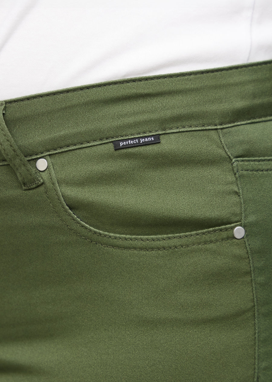 Forlommen på et par mørkegrønne loose jeans, hvor man kan se logoet på en plus-size model.