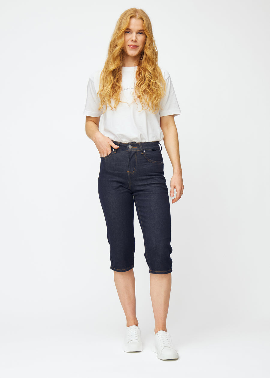 Model viser dyb mørkeblå denim capris til kvinder i farven Midnights med regular pasform i bevægelse.