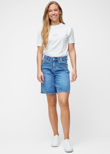 Model viser løse, klassisk blå denim shorts i farven Rivers i bevægelse og demonstrerer pasform og materiale.